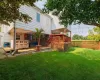 Back of house featuring a deck, a lawn, and a fenced backyard