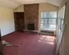 Unfurnished living room featuring carpet flooring, radiator heating unit, a fireplace, and vaulted ceiling