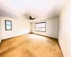 Carpeted spare room featuring a textured ceiling, baseboards, and a ceiling fan