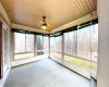 Unfurnished sunroom with wood ceiling and a ceiling fan