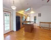 Kitchen with dark countertops, visible vents, stainless steel double oven, a peninsula, and black fridge with ice dispenser