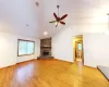 Unfurnished living room featuring visible vents, lofted ceiling, a fireplace, ceiling fan, and light wood-type flooring