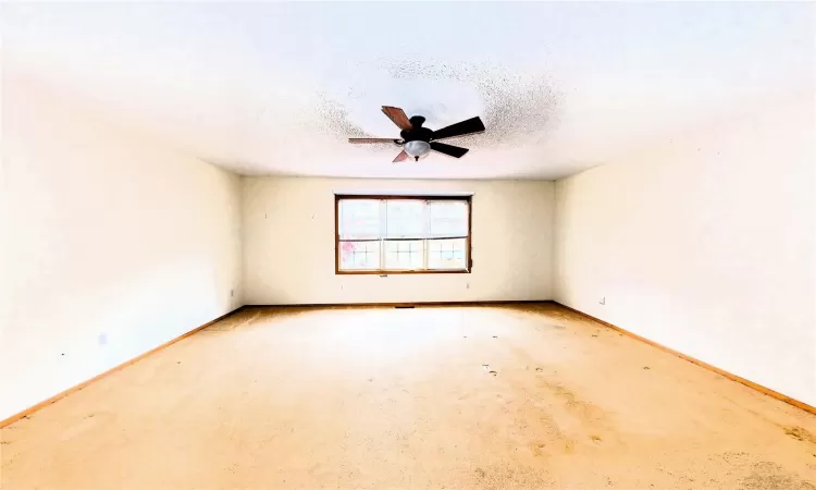 Unfurnished room with baseboards, a textured ceiling, and a ceiling fan