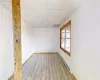 Empty room with a baseboard heating unit, wood finished floors, a paneled ceiling, and baseboards