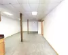 Finished basement featuring a paneled ceiling, baseboards, and carpet flooring