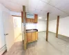 Kitchen with dark countertops, a drop ceiling, baseboard heating, and carpet floors