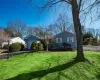 View of front of home with a garage, driveway, a front yard, and fence