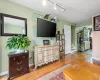 Living room with rail lighting, light wood-type flooring, baseboards, and stairs