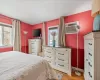 Bedroom featuring an AC wall unit, light wood-type flooring, and baseboards