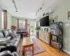 Living room with light wood finished floors, track lighting, and baseboards