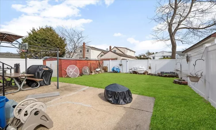 View of yard with a patio area, a fenced backyard, and an outdoor structure