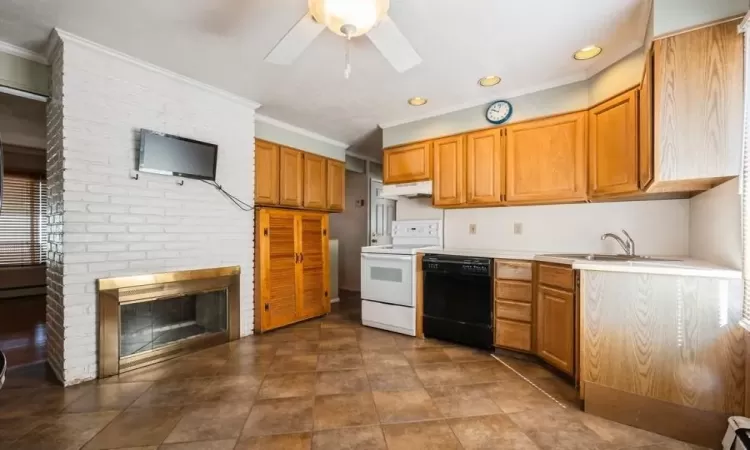 Kitchen featuring electric range, a sink, light countertops, under cabinet range hood, and dishwasher