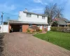 Traditional home featuring brick siding, a front yard, a chimney, decorative driveway, and an attached garage