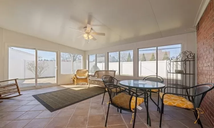 Sunroom featuring ceiling fan and vaulted ceiling