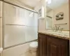 Full bathroom featuring tile patterned flooring, toilet, vanity, and shower / bath combination with glass door