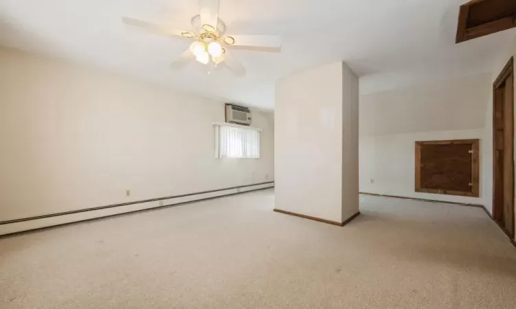 Carpeted empty room with baseboard heating, baseboards, a wall mounted AC, and ceiling fan