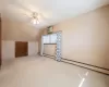 Bonus room featuring a wall unit AC, a baseboard radiator, light colored carpet, ceiling fan, and vaulted ceiling