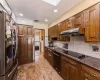 Kitchen featuring black appliances, under cabinet range hood, a sink, tasteful backsplash, and recessed lighting