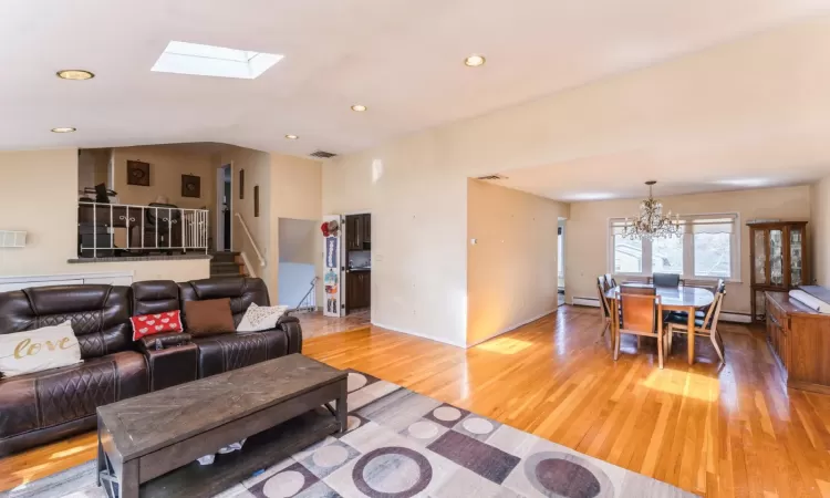 Living room with recessed lighting, visible vents, a chandelier, and light wood finished floors