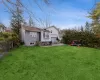 Rear view of house featuring fence, central AC unit, a chimney, a yard, and a patio