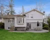 Back of house featuring a yard, a patio, brick siding, and roof with shingles