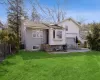 Rear view of house featuring brick siding, fence, a lawn, central AC unit, and a patio area