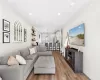 Living room with recessed lighting, baseboards, crown molding, and light wood-style floors