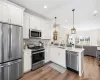 Kitchen featuring visible vents, a peninsula, a sink, appliances with stainless steel finishes, and open floor plan