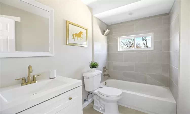 Bathroom with tub / shower combination, toilet, and vanity