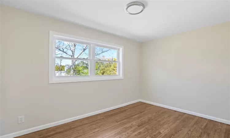 Unfurnished room with baseboards and wood finished floors