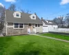 Cape cod house with a front lawn, a garage, new asphalt driveway