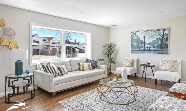 Living area featuring visible vents, baseboards, and wood finished floors