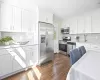 Kitchen featuring stainless steel appliances, dark wood-type flooring, white cabinets, and light countertops