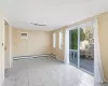 Empty room featuring a wealth of natural light, a baseboard heating unit, and a wall unit AC