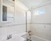 Full bathroom with tub / shower combination, crown molding, toilet, tile walls, and a sink