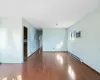 Spare room featuring baseboard heating, a wall mounted AC, baseboards, and wood-type flooring