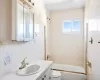 Bathroom with tasteful backsplash, tile walls, toilet, shower / tub combination, and vanity