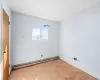 Unfurnished room with baseboard heating