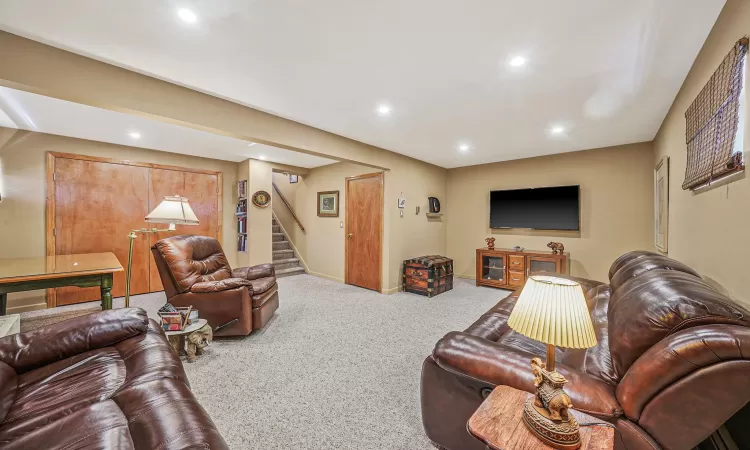 Carpeted living room with stairway, recessed lighting, and baseboards