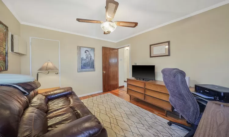 Office space with ornamental molding, baseboards, a ceiling fan, and wood finished floors