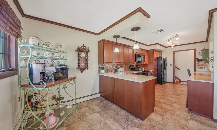 Kitchen featuring visible vents, black appliances, a sink, brown cabinetry, and light countertops