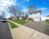 View of front facade featuring a front lawn, fence, aphalt driveway, a residential view, and a gate