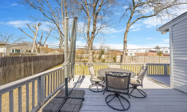 Deck featuring outdoor dining area, a residential view, and fence