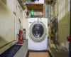 Washroom featuring electric panel, laundry area, and washer / clothes dryer