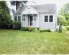 Bungalow featuring a front yard and a chimney