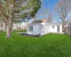 Rear view of house featuring fence and a lawn