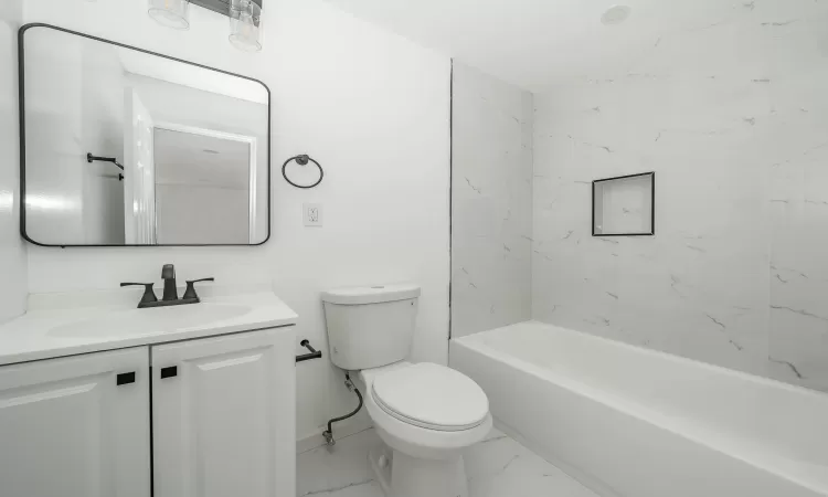 Bathroom featuring vanity, toilet, baseboards, and marble finish floor