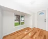 Foyer with baseboards and wood finished floors