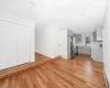 Kitchen with gray cabinetry, stainless steel appliances, light wood-style floors, light countertops, and baseboard heating