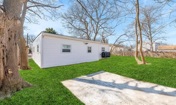 Rear view of property with a patio, a lawn, heating fuel, and fence